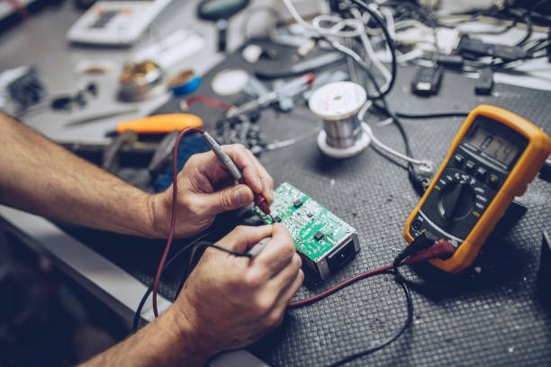 Engineer or technician repair electronic circuit board with soldering iron